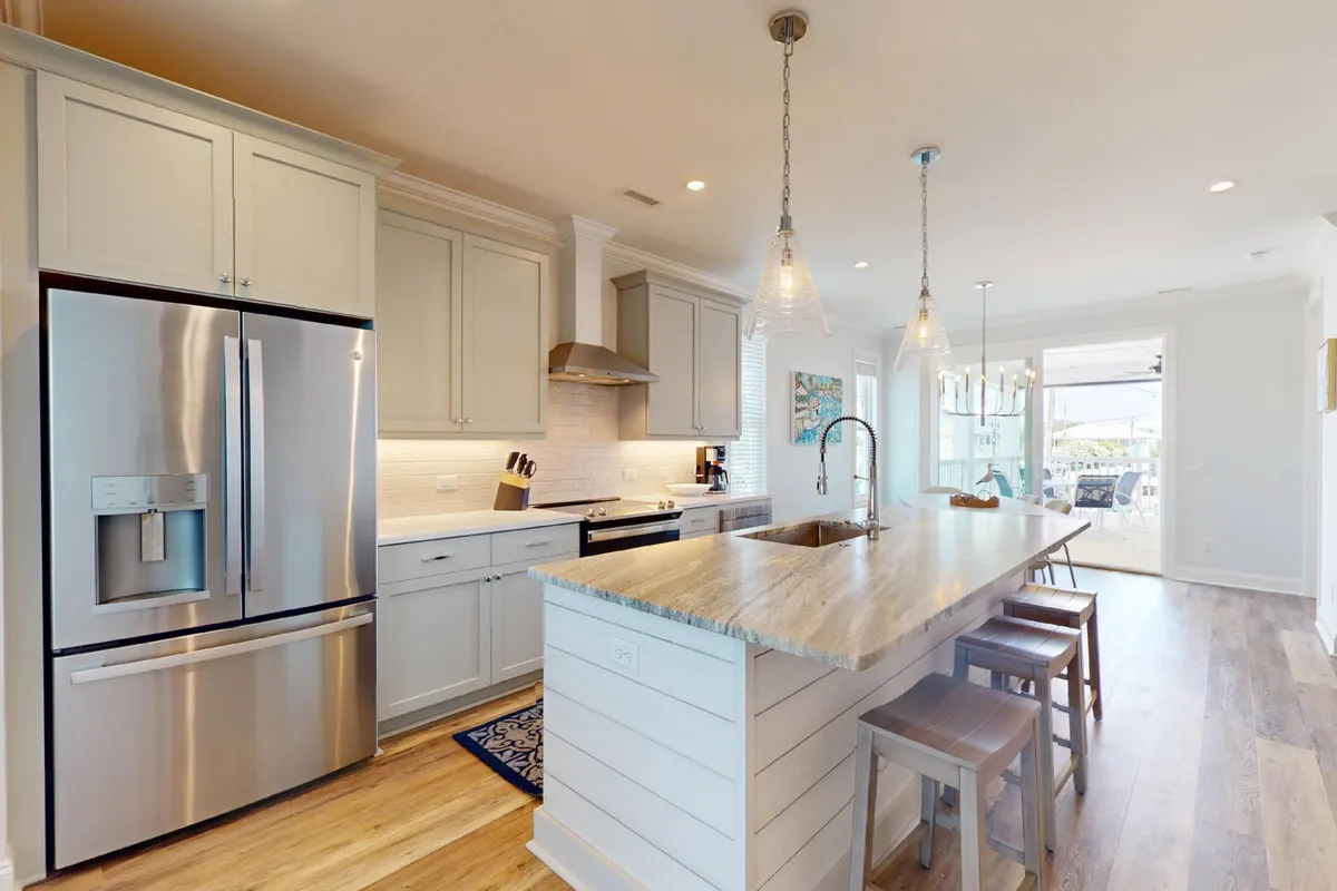 A modern kitchen with a central island, stainless steel appliances, and thoughtful lighting. The layout is ideal for cooking, entertaining, and bringing people together, offering a glimpse of the gourmet amenities available.